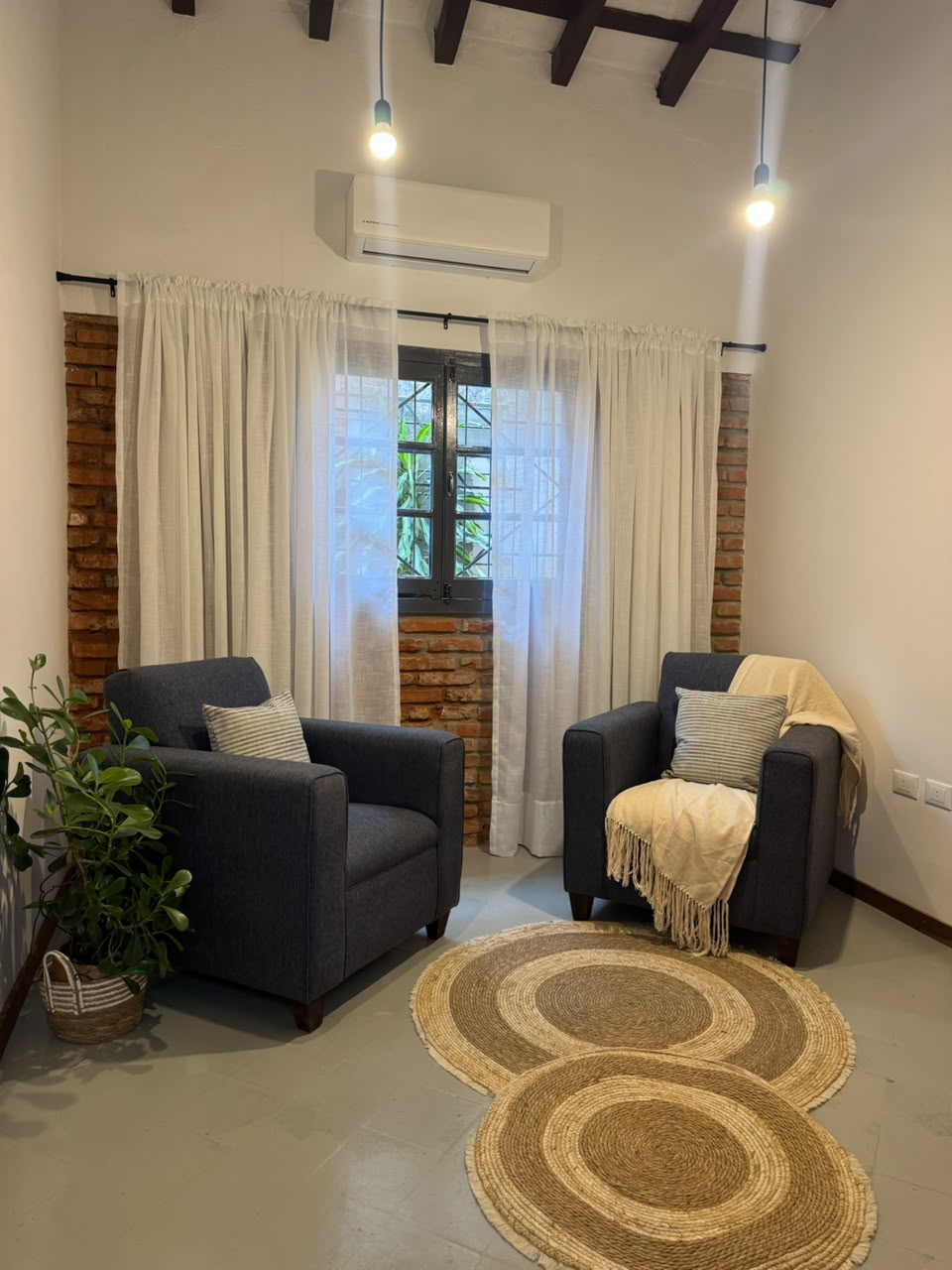 Sala de terapia con dos sillones, luz cálida y plantas